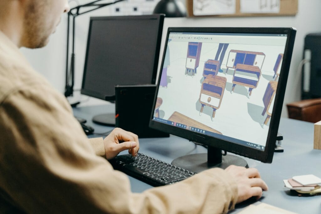 widok na ekran z projektem 3D oraz pracującym przy nim konstruktorem